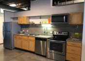 Thumbnail 29 of 34 - a kitchen with stainless steel appliances and wooden cabinets