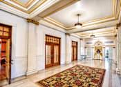 Thumbnail 3 of 16 - A large, ornate hallway with a patterned carpet and a chandelier.