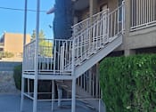 Thumbnail 1 of 3 - an apartment building with white stairs and a blue awning