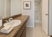 Thumbnail 13 of 47 - A bathroom with a sink, mirror, and a white door.