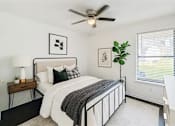 Thumbnail 2 of 47 - A bedroom with a bed, a ceiling fan, and a window with blinds.