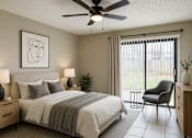 Thumbnail 30 of 47 - A bedroom with a bed, a chair, and a ceiling fan.