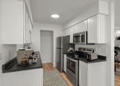 Thumbnail 3 of 28 - A modern kitchen with white cabinets and black countertops. at Osage Creek, Arkansas, 72756