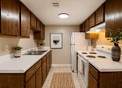 Thumbnail 4 of 47 - A kitchen with brown cabinets and white appliances.