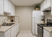 Thumbnail 31 of 47 - A kitchen with white cabinets and a black stove top oven.