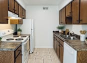 Thumbnail 24 of 47 - A kitchen with white appliances and wooden cabinets.