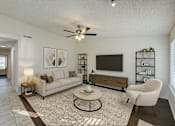Thumbnail 28 of 47 - A living room with a white couch, a coffee table, and a television.