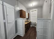 Thumbnail 13 of 13 - A kitchen with white cabinets and a wooden counter.