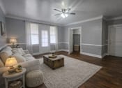 Thumbnail 3 of 13 - A living room with a white couch, a wooden coffee table, and a rug.
