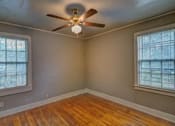 Thumbnail 14 of 15 - A room with a ceiling fan and two windows.