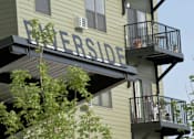 Thumbnail 7 of 7 - A balcony with a metal railing and a tree in front of a building with the word "Everside" on it.