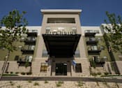 Thumbnail 5 of 7 - The Riverside building has a modern design with balconies on the second floor.