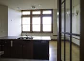 Thumbnail 92 of 100 - A kitchen with dark wood cabinets and a sink under a window.