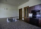 Thumbnail 93 of 100 - A kitchen with a black oven and a sink.