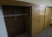 Thumbnail 10 of 100 - A wooden closet with a shelf and two doors.