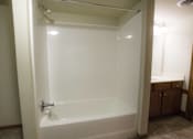 Thumbnail 12 of 100 - A white bathtub with a shower head and a faucet.