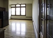 Thumbnail 1 of 100 - A kitchen with a black fridge and wooden floors.