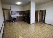 Thumbnail 2 of 100 - A kitchen area with wooden floors and a refrigerator.