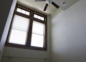 Thumbnail 35 of 100 - A window with blinds and a ceiling fan in a room.