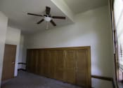 Thumbnail 37 of 100 - A room with a ceiling fan and a large wooden wardrobe.