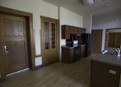 Thumbnail 38 of 100 - A kitchen with wooden floors and cabinets.