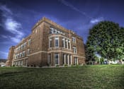 Thumbnail 45 of 100 - A large red brick building with a green lawn in front.