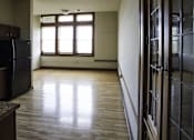 Thumbnail 51 of 100 - A room with a black fridge and wooden flooring.