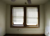 Thumbnail 54 of 100 - A room with a window covered in blinds.