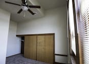 Thumbnail 58 of 100 - A room with a ceiling fan and a window with blinds.