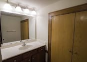 Thumbnail 61 of 100 - A bathroom with a sink, mirror, and wooden cabinet.