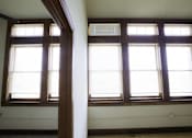 Thumbnail 63 of 100 - Two windows with blinds in a room with wooden beams.