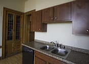 Thumbnail 64 of 100 - A kitchen with a black dishwasher and a sink with a granite counter top.