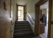 Thumbnail 66 of 100 - A hallway with a staircase leading to a second floor.