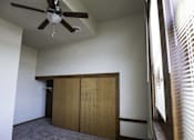 Thumbnail 8 of 100 - A room with a ceiling fan and a window with blinds.