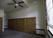 Thumbnail 83 of 100 - A room with a ceiling fan and a row of cupboards.