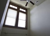 Thumbnail 85 of 100 - A room with a ceiling fan and a window with blinds.