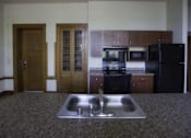 Thumbnail 89 of 100 - A kitchen with a sink and a refrigerator.