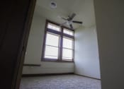 Thumbnail 9 of 100 - A room with a ceiling fan and a window.
