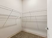 Thumbnail 10 of 29 - A walk-in closet with shelves and carpeted floor.