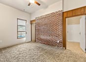 Thumbnail 13 of 29 - A room with a brick wall and a ceiling fan.