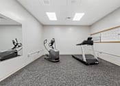 Thumbnail 4 of 29 - A room with a treadmill, stationary bike, and rowing machine.