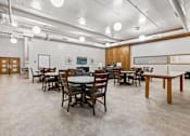 Thumbnail 2 of 29 - A room with tables and chairs and a white ceiling.