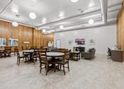 Thumbnail 3 of 29 - A room with tables and chairs and a white ceiling.