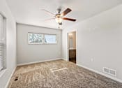 Thumbnail 28 of 29 - A room with a ceiling fan and carpeted floor.