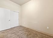 Thumbnail 23 of 29 - A room with a white door and carpeted floor.