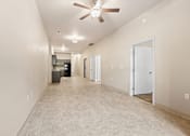 Thumbnail 8 of 29 - A long hallway with a fan and a door on the right.