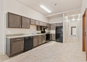 Thumbnail 6 of 29 - A kitchen with brown cabinets and black appliances.