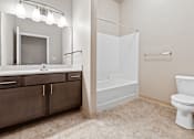 Thumbnail 11 of 29 - A white toilet sits in a bathroom next to a walk-in shower.