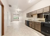 Thumbnail 7 of 29 - A kitchen with black appliances and wooden cabinets.