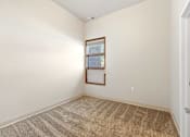 Thumbnail 16 of 29 - A room with a carpeted floor and a window with blinds.